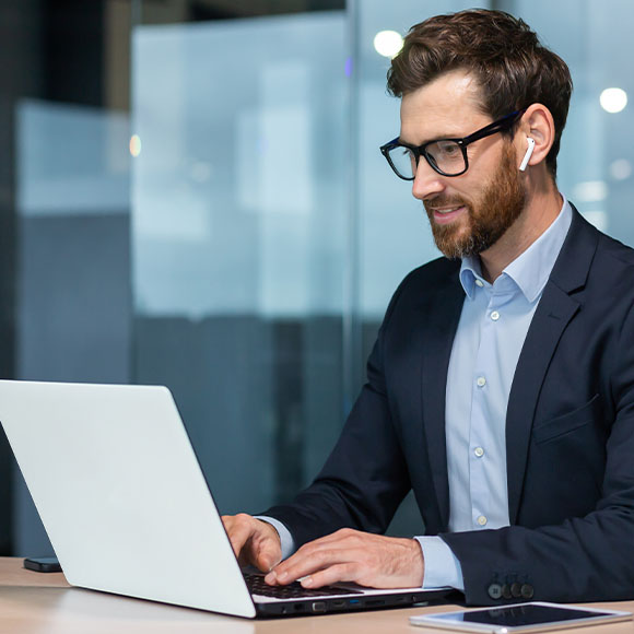 a man wearing earbuds using a laptop