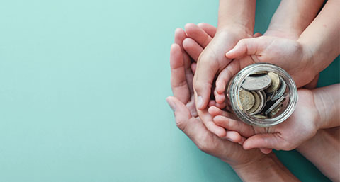 a family of people holding a jar of coins